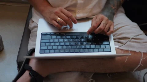 Tattooed Person Typing or Working on Laptop Keyboard While... 動画素材 334436945