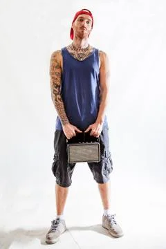 Tattooed rap singer posing in studio with an amplified radio Stock Photos