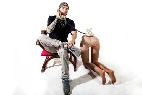 Tattooed rap singer posing in studio with a female dummy Foto stock