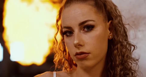 Tattooed woman with fire explosion in dramatic cinematic scene, close up Stock Footage 310728664