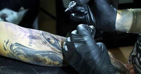 Tattooist draws a pattern on clients arm Stock Footage 139708046