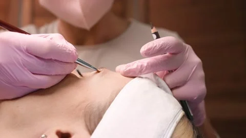 Tattooist making permanent make-up. Attractive lady getting Stock Footage 149007309