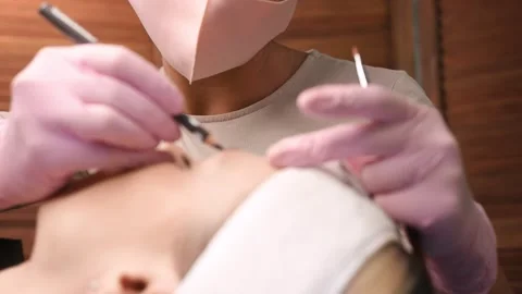 Tattooist making permanent make-up. Attractive lady getting 스톡 동영상 149007312