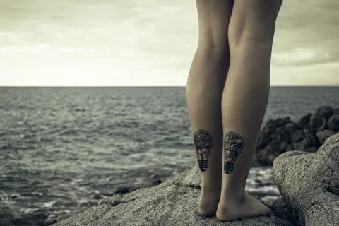 Tattoos legs at the coast Stock Photos