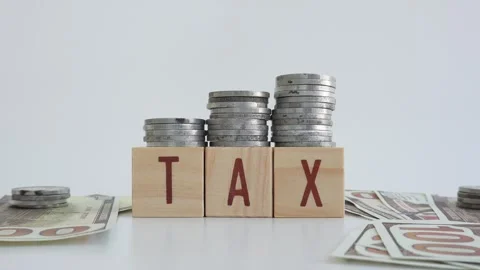 Tax concept using wooden blocks with TAX written on them and dollar bills Stock Footage 333031433