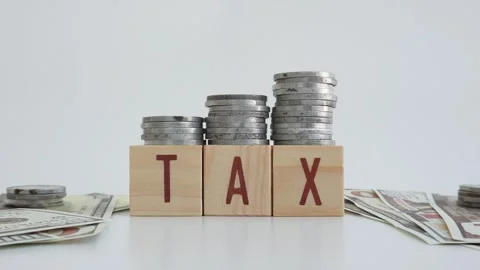Tax concept using wooden blocks with TAX written on them and dollar bills Stock Footage 333031436