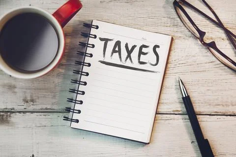 Taxes text on notebook Stock Photos