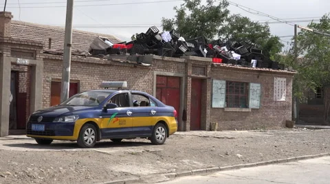 Taxi and piled plastic crates in poor neighborhood, Jiayuguan Stock Footage 47454959