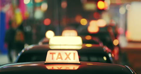 Taxi cabs at night time on city street with defocused lights. Hong Kong downtown Stock Footage