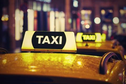 Taxi car on the street at night Stock Photos