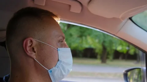 Taxi driver in a protective mask inside the car during the coronavirus pandemic Stock Footage 138311738