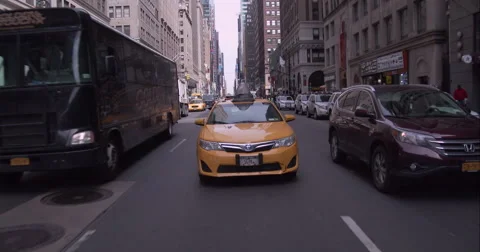 Taxi following the camera down 7th Avenue in midtown Manhattan Stock Footage 51241867