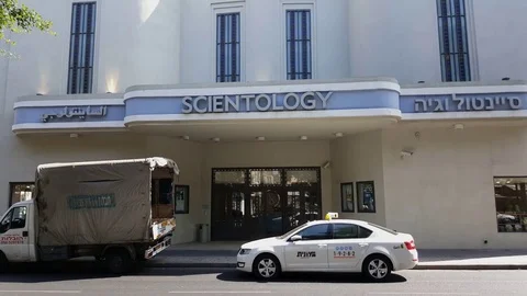 Taxi parked at Scientology building in Jaffa, sign in Hebrew, Arabic, English Stock Footage