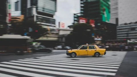 Taxi speeding across Shibuya crossing in Tokyo Japan Stock Photos