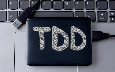 TDD - acronym on an external drive in gray letters on the background of a l.. Stock Photos