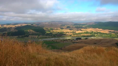 Te Mata Peak to clouds, river and hills with yellow grass Stock Footage 131774804