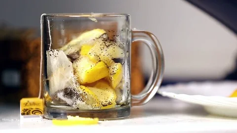 Tea and many lemons being poured into tea cup Stockbeeldmateriaal 72501352