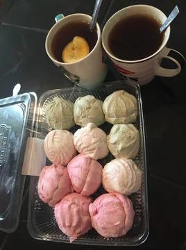 Tea and multicolored marshmallows on black table Stock Photos