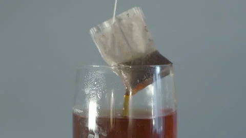 Tea bag being pulled out and put back into cup of tea in slow motion Stock Footage 141041091