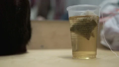 The tea bag is brewed in a transparent plastic Cup Vídeos de archivo 103389403