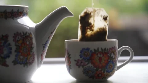 Tea bag in cup and kettle next to it Stock Footage 250765076