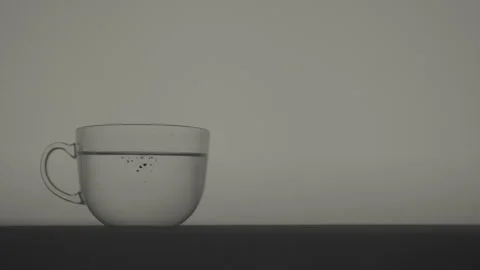 Tea Bag Dropping Into Clear Water With Initial Tea Diffusion Stock Footage 346364215