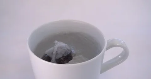 Tea bag falling into hot cup of boiling water Vídeo Stock 91453462