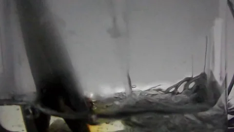 Tea bag in a glass cup being filled with hot water to make tea. Video stock 80023901