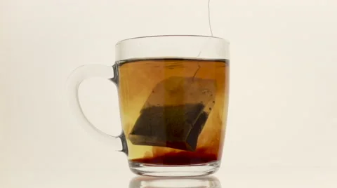 Tea bag in hot water on the white background Stock Footage 54937075