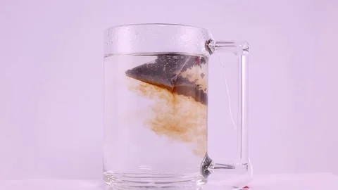 A tea bag immersed in water to steep and make an infusion Stock Footage 168358458