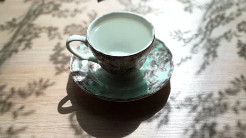 The tea bag is put in a cup. Steam comes out of the cup. Beautiful shadow is on Stock Footage 133998492