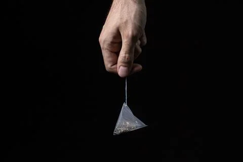 Tea bag pyramid on a black background. Fast brewing tea. Stock Photos