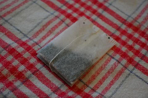 Tea Bag on Red Checkered Tablecloth Close-Up, Home Tea Time Concept Fotos Stock