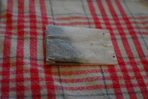 Tea Bag on Red Checkered Tablecloth Close-Up, Home Tea Time Concept Photos
