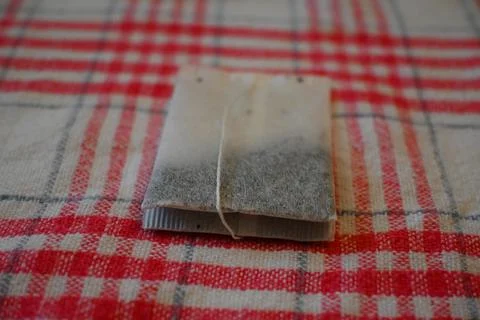 Tea Bag on Red Checkered Tablecloth Close-Up, Home Tea Time Concept Photos