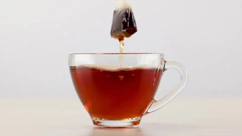 Tea Bag Steeping and Dipping in Glass Cup of Hot Water Stock Footage 341536110
