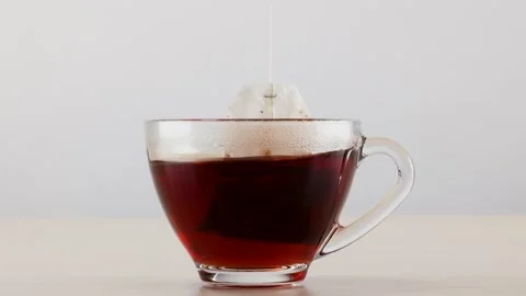 Tea Bag Steeping in Glass Cup of Hot Water Stock Footage 345016160