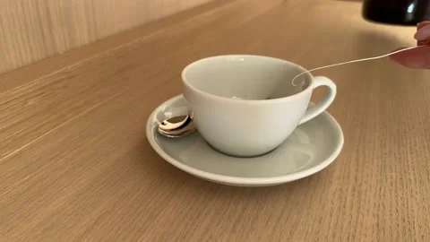 Tea bag in a white cup of tea. Making morning tea in hotel room. 4K Stock Footage 232222636