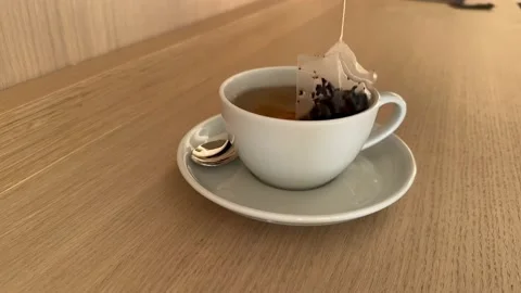 Tea bag in a white cup of tea. Making morning tea in hotel room. 4K Stock Footage 232222643