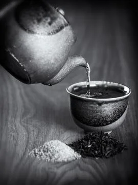 Tea being poured into a ceramic cup from a teapot Stock Photos