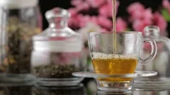 Tea Pouring. Tea Being Poured Into Glass Transparent Tea Cup. Tea