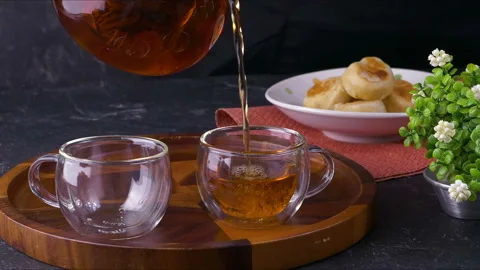 Tea being poured into tea cup. Dessert and hot drink. Stock Footage 130266954