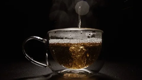 Tea. Black tea is poured into the cup. Stock Footage 128940782