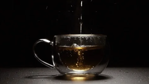 Tea. Black tea is poured into the cup. Shot in slow motion. Video stock 128940808