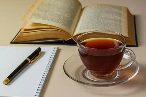 Tea, book and notebook on white table Stock Photos
