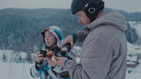 Tea break during skiing on the mountain. Man and woman drinking tea at a ski Stock Footage 72374251