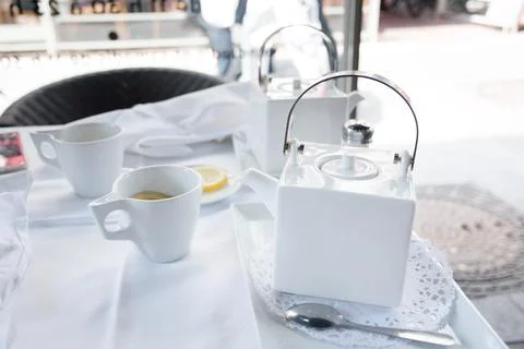 Tea break with a white tea set at a table in a cafe in the city Stock Photos