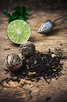 Tea brew with lime and mint on wooden background Stock Photos