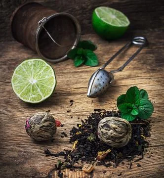 Tea brew with lime and mint on wooden background Stock Photos