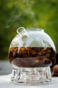 Tea is brewed in a glass teapot. Stock Photos